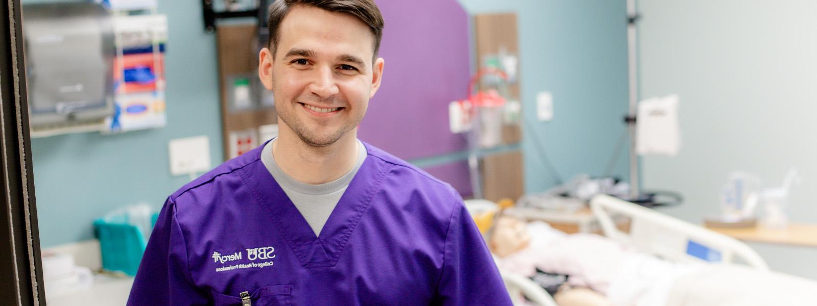 nursing student smiling with simulation lab in background